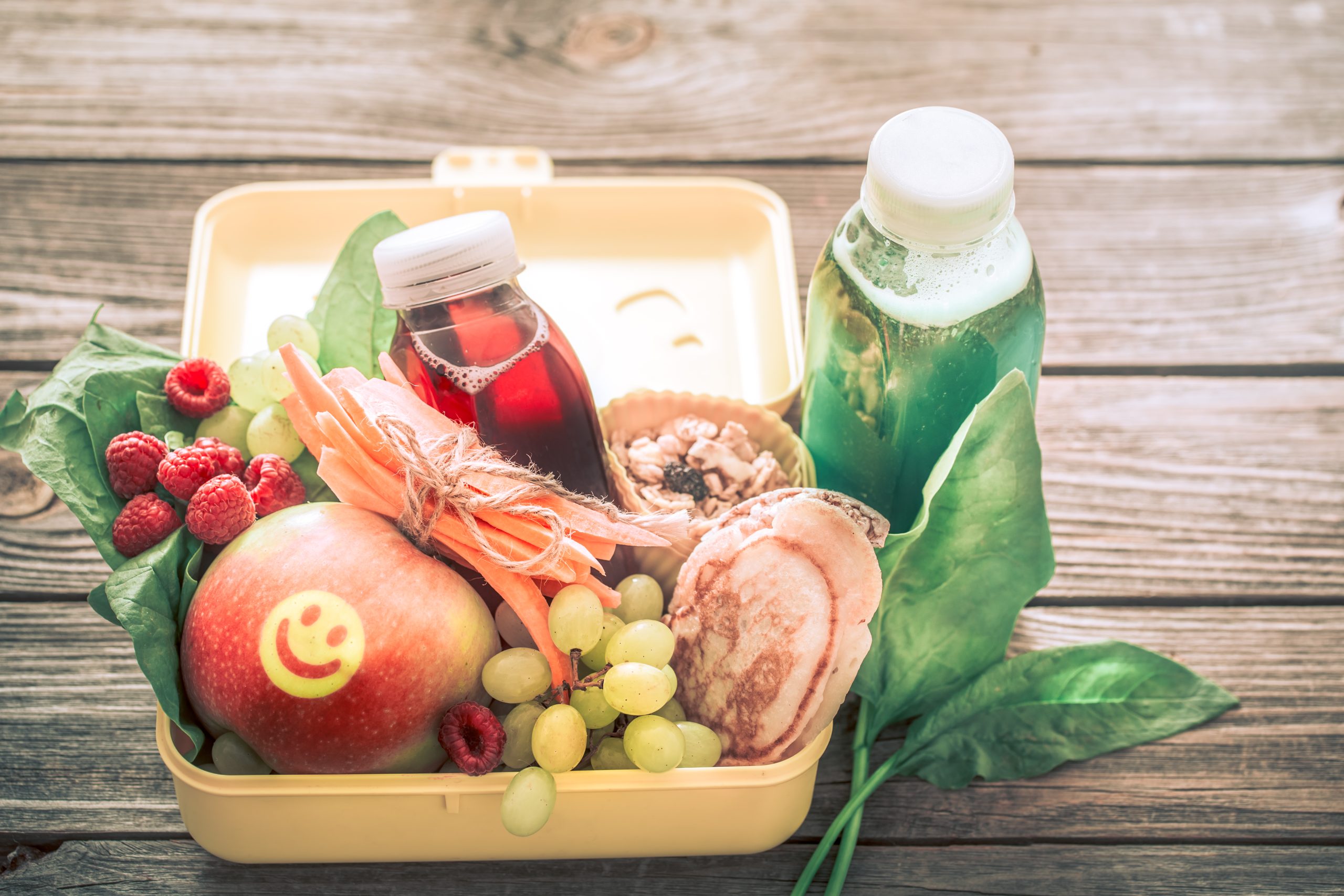breakfast or lunch with healthy food in a yellow box, on a woode